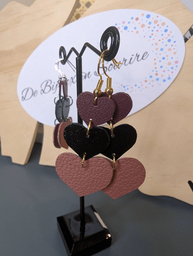 Boucles d'oreilles double face, en forme de cœur, avec du cuir véritable rose et noir texturé, le fermoir est de couleur or hypoallergénique. 