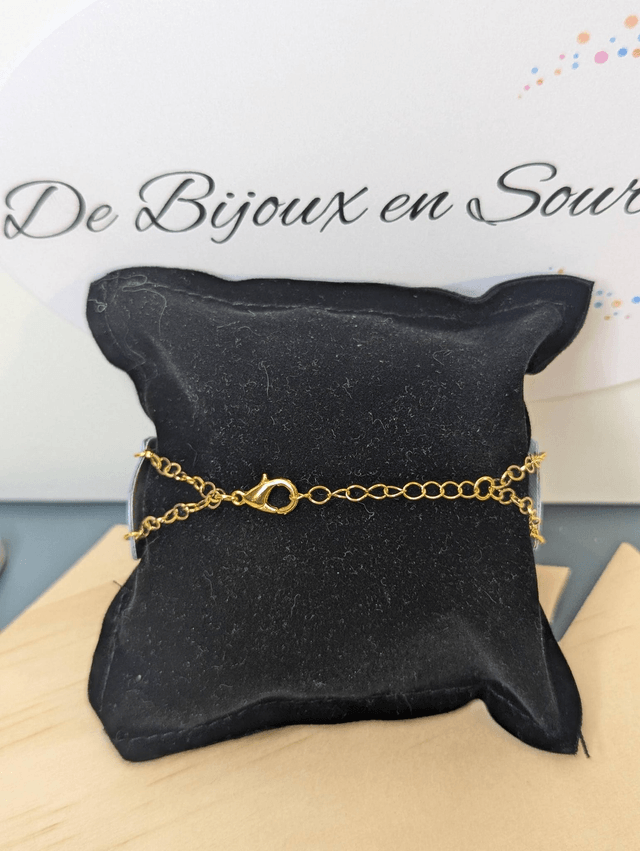 Bracelet manchette en cuir bleu lisse, avec du tissus enduit blanc (résistant), une chaine dorée. Le fermoir est de couleur or. 