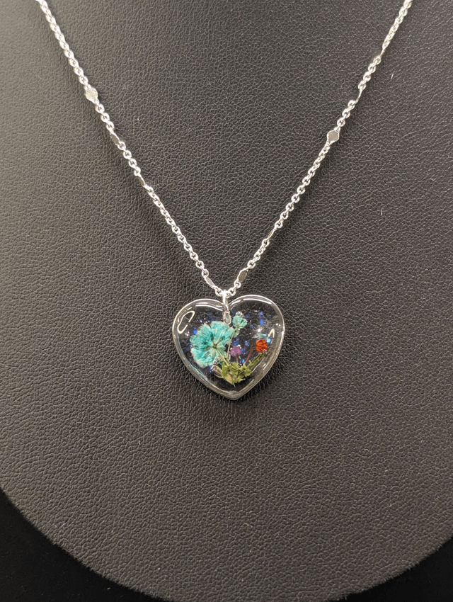 Collier avec chaine argent et pendentif en forme de cœur et fleurs séchées. 