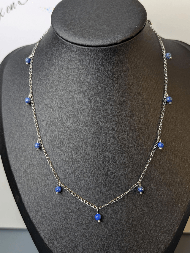 collier court chaine en argent fine et des perles naturelles de lapis lazuli de couleur bleu, la chaine fermoir est de couleur argent. 
