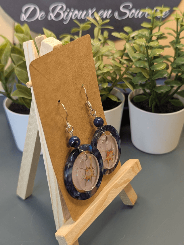 Boucles d'oreilles avec 2 pendentifs ronds, des perles naturelles et un fermoir couleur argent. 