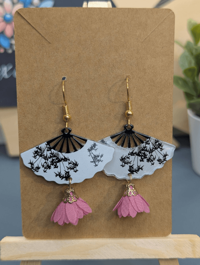 Boucles d'oreilles avec breloque éventail et pompon rose.