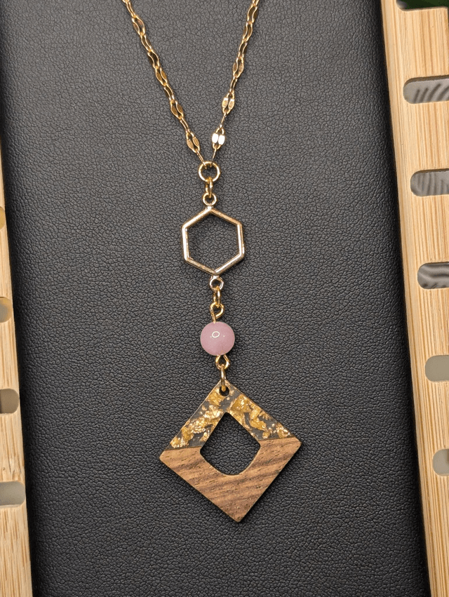Collier long, sautoir, avec une chaine de couleur or, des perles naturelles, un pendentif en métal et pendentif en bois.