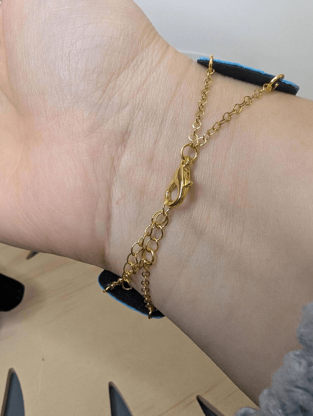 Bracelet manchette en cuir bleu, avec du tissus enduit bleu foncé (résistant), une chaine dorée. Le fermoir est de couleur doré.