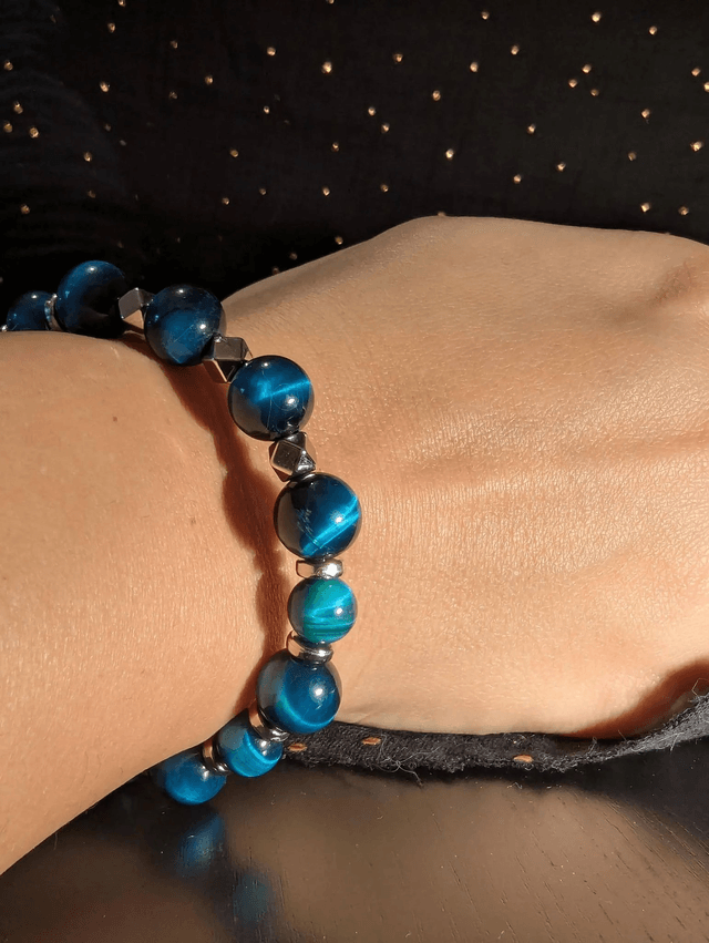 Bracelet en perles d'œil de tigre bleu et des perles d'espacement plate en argent. Le fermoir et la chaine fermoir sont en argent.