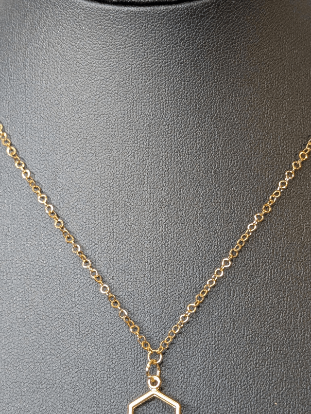 Collier mi long avec une chaine de couleur or et un pendentif en résine rose et noir et un pendentif en métal doré.