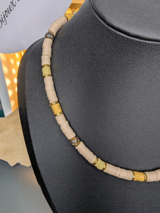 collier ras de cou avec des perles plates heishi de couleurs jaune, beige et or intercalé de perles de lave volcanique doré. 