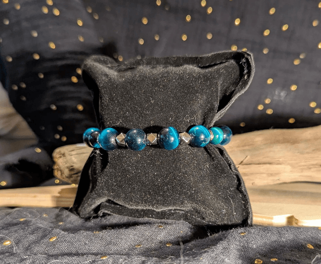 Bracelet en perles d'œil de tigre bleu et des perles d'espacement plate en argent. Le fermoir et la chaine fermoir sont en argent.
