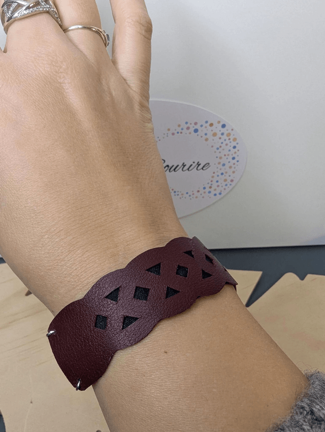 Bracelet manchette en cuir rouge Bordeau, avec du tissus enduit noir (résistant), une chaine couleur argent. le fermoir est de couleur argent.