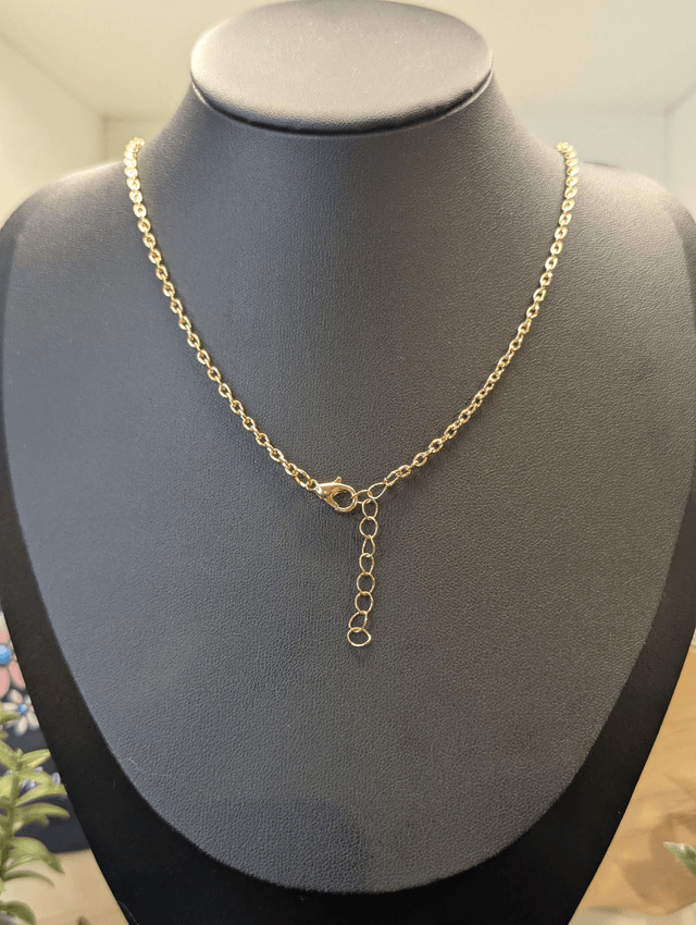 Collier avec pendentif en résine transparente te marron en forme de triangle.
