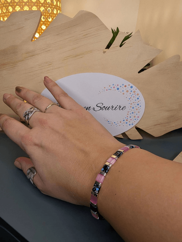 Bracelet en perles plate en verre rose et noire, avec des perles en métal argenté. Le fermoir et la chaine fermoir sont en argent.