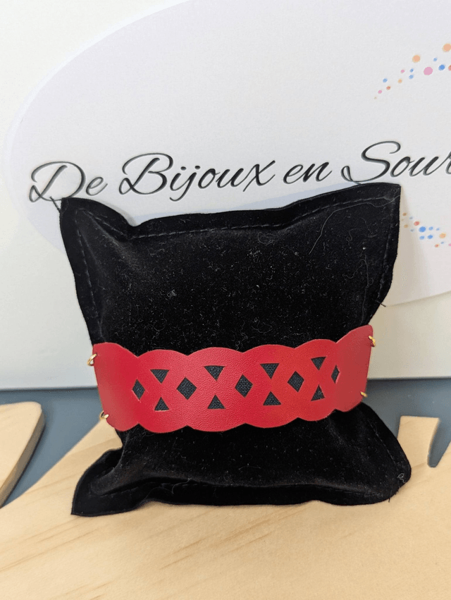 Bracelet manchette en cuir rouge, avec du tissus enduit bleu foncé (résistant), une chaine en or. Le fermoir est de couleur or.