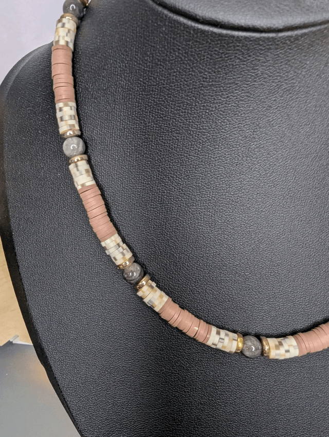 collier ras de cou avec des perles plates heishi couleurs marron, blanc cassé et or, ainsi que des perles naturelles. 