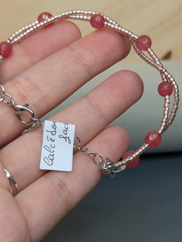 Bracelet torsadé rose métallisé, avec des perles Miyuki en verre et des perles naturelles sur fil de fer. Le fermoir est de couleur argent.