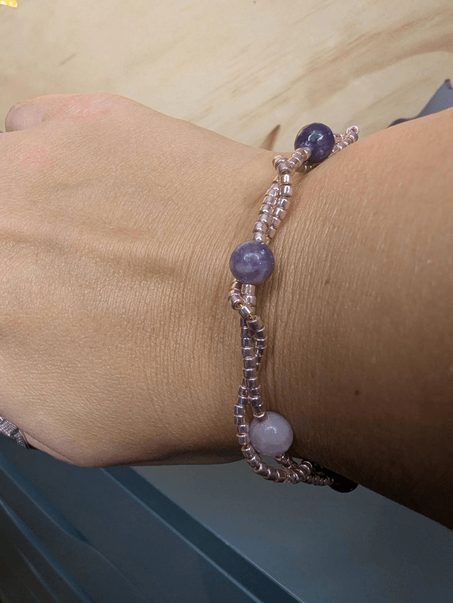Bracelet torsadé violet foncé, avec des perles Miyuki en verre et des perles naturelles violettes sur fil de fer. le fermoir est de couleur or.