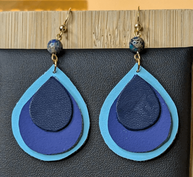 Boucles d&#039;oreilles pendante en similicuir et en tissus enduit dégradé bleu. Perles naturelles, fermoir de couleur or.