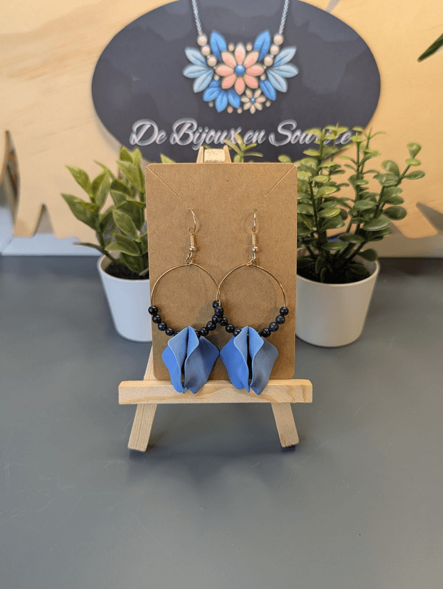 Petites boucle d&#039;oreille créole en perles naturelles noire et des breloque en forme de pétales bleu. 