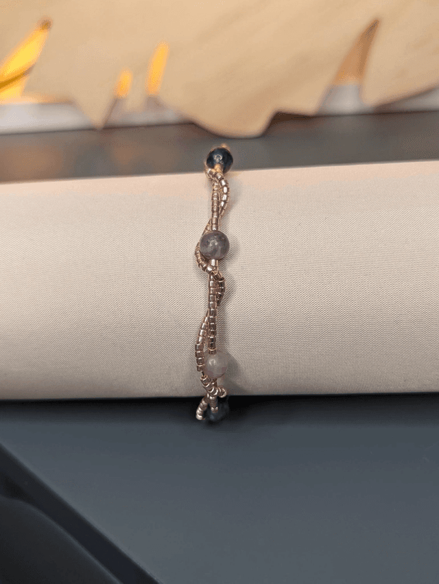 Bracelet torsadé violet foncé, avec des perles Miyuki en verre et des perles naturelles violettes sur fil de fer. le fermoir est de couleur or.