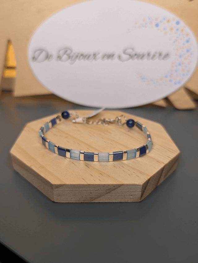 Bracelet en perles plate en verre bleu et perles d&#039;espacement en métal argenté. Le fermoir et le chaine fermoir sont en argent.