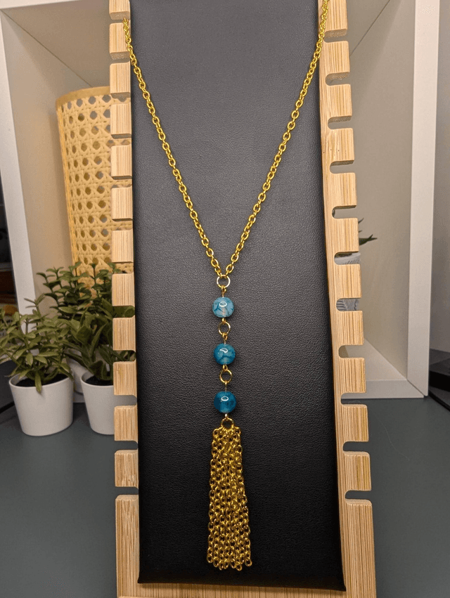 Collier long, sautoir, chaine de couleur or, avec des perles naturelles d&#039;agate bleu-vert et un pompon en chaine doré.