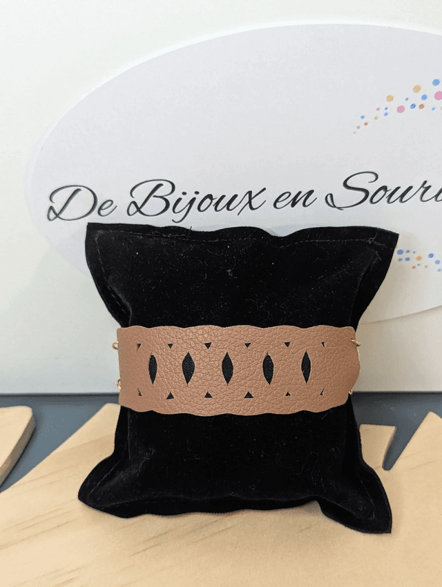 Bracelet manchette en cuir marron clair, avec du tissus enduit noir (résistant), une chaine dorée. Le fermoir est de couleur or.