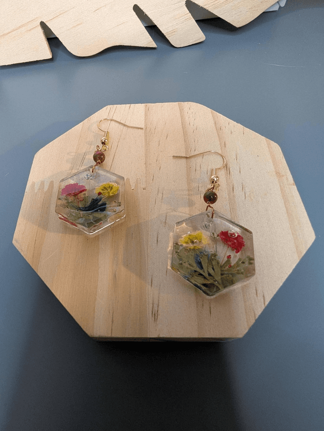 Boucles d&#039;oreilles avec un pendentif hexagonale en résine avec des fleurs séchés, des perle naturelle rose et un fermoir en or rosé,