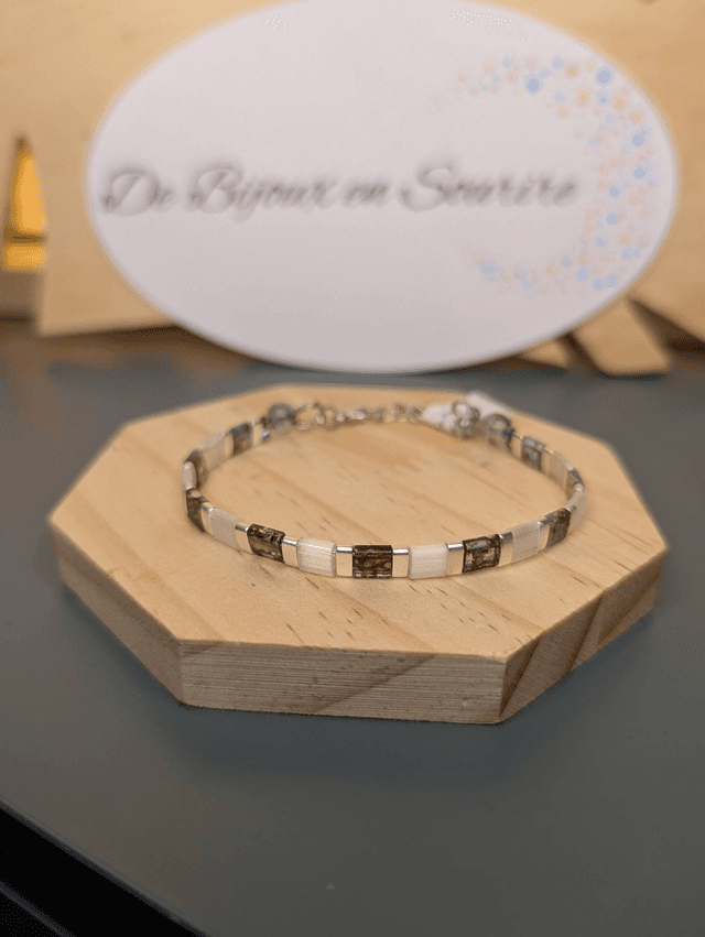 Bracelet en perles plate en verre blanc avec des  perles d&#039;espacement en métal argenté. Le fermoir et la chaine fermoir sont en argent.
