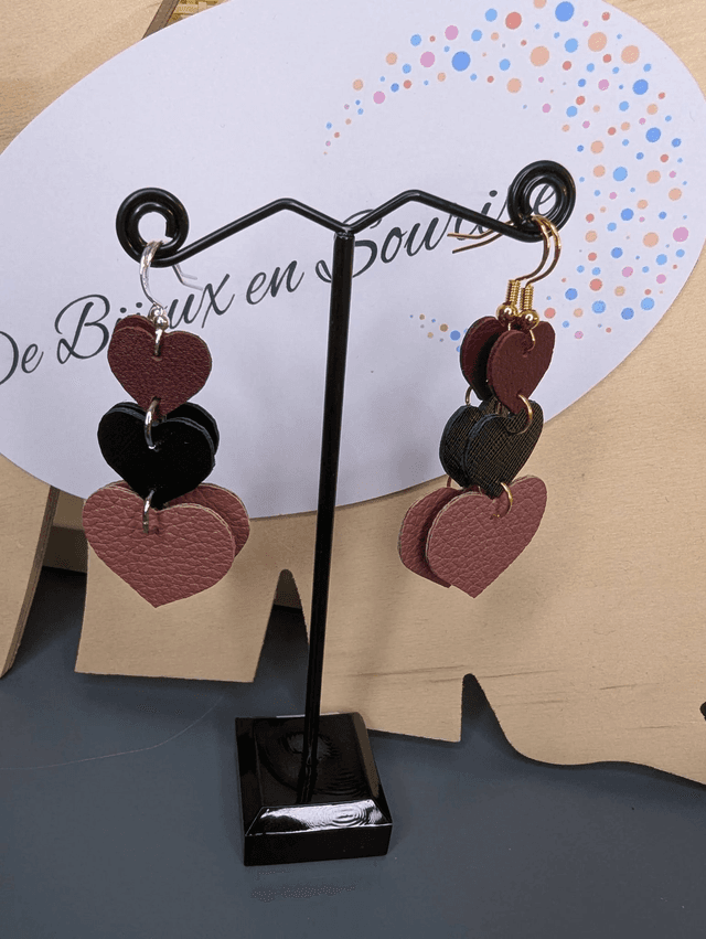 Boucles d&#039;oreilles double face, en forme de cœur, avec du cuir véritable rose et noir texturé, le fermoir est de couleur or hypoallergénique. 