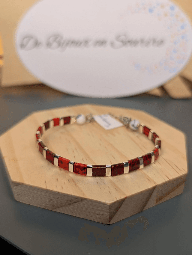 Bracelet en perles plate en verre rouge, perles d&#039;espacement en métal argenté. le fermoir et la chaine fermoir sont en argent. 