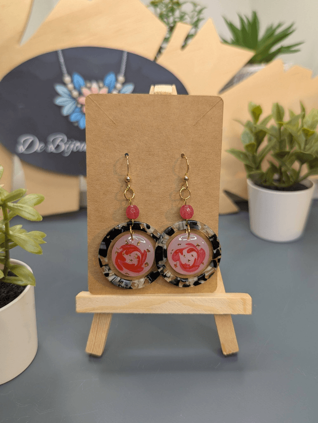 Boucles d&#039;oreilles avec 2 pendentifs ronds, des perles naturelles et un fermoir couleur or. 